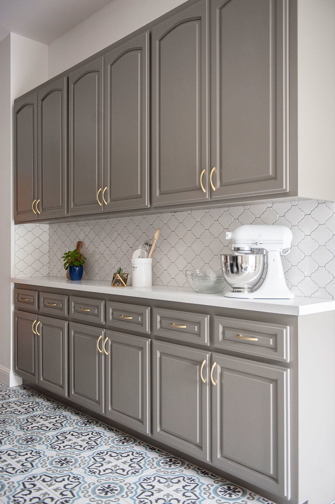 Idéer för ett litet modernt kök, med grå skåp, vitt stänkskydd, stänkskydd i keramik, cementgolv, luckor med upphöjd panel och rostfria vitvaror