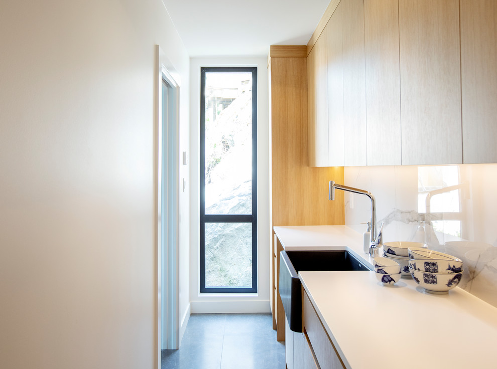 Exempel på ett litet modernt vit linjärt vitt kök och matrum, med en undermonterad diskho, släta luckor, skåp i mellenmörkt trä, bänkskiva i kvarts, vitt stänkskydd, rostfria vitvaror, klinkergolv i porslin, en köksö och grått golv