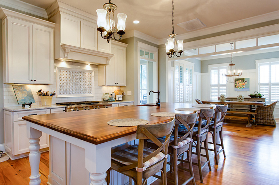 Immagine di una cucina classica con ante bianche, paraspruzzi bianco e pavimento in legno massello medio