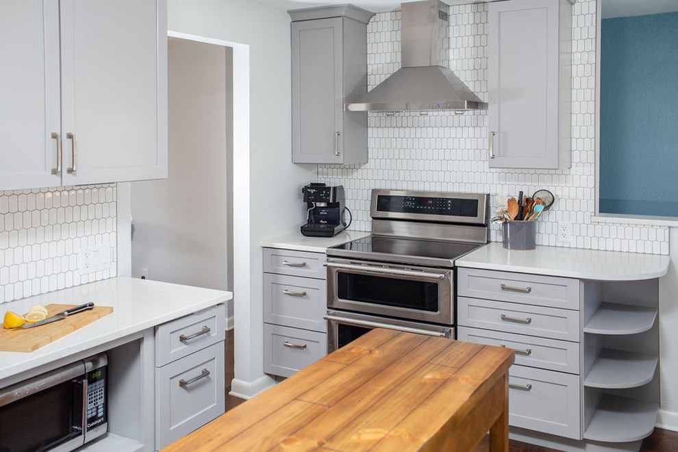 Idéer för att renovera ett mellanstort vintage vit vitt kök, med en undermonterad diskho, skåp i shakerstil, grå skåp, bänkskiva i kvarts, vitt stänkskydd, stänkskydd i keramik, rostfria vitvaror, mellanmörkt trägolv, en köksö och brunt golv