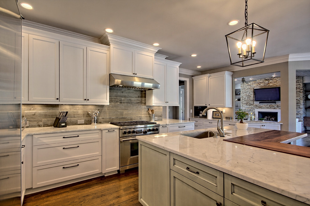 Exempel på ett klassiskt kök, med en enkel diskho, skåp i shakerstil, vita skåp, marmorbänkskiva, stänkskydd i porslinskakel, rostfria vitvaror, mellanmörkt trägolv och en köksö