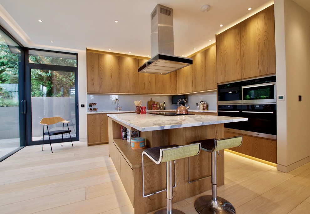 Photo of a contemporary kitchen in London with marble worktops, glass sheet splashback, light hardwood flooring and an island.