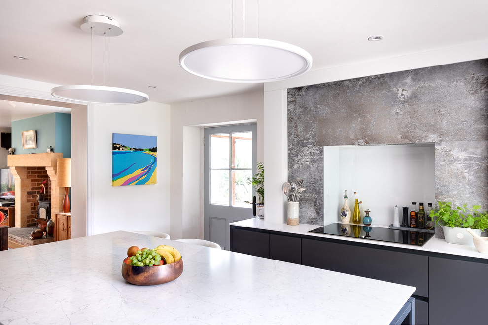 Esempio di una cucina minimalista di medie dimensioni con lavello da incasso, ante lisce, top in superficie solida, paraspruzzi in legno, elettrodomestici neri, pavimento beige e top bianco