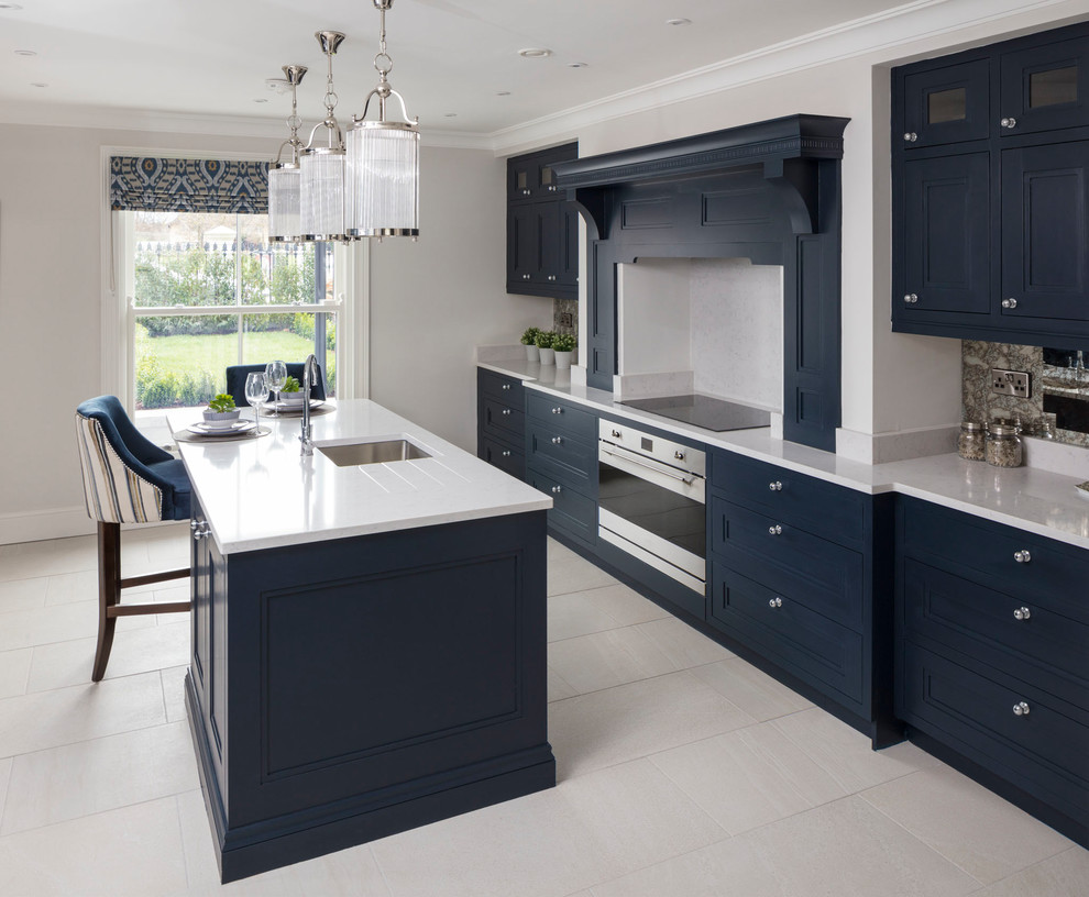 Klassische Küche mit integriertem Waschbecken, Schrankfronten im Shaker-Stil, blauen Schränken, Quarzit-Arbeitsplatte, Rückwand aus Spiegelfliesen, Küchengeräten aus Edelstahl und Kücheninsel in Dublin