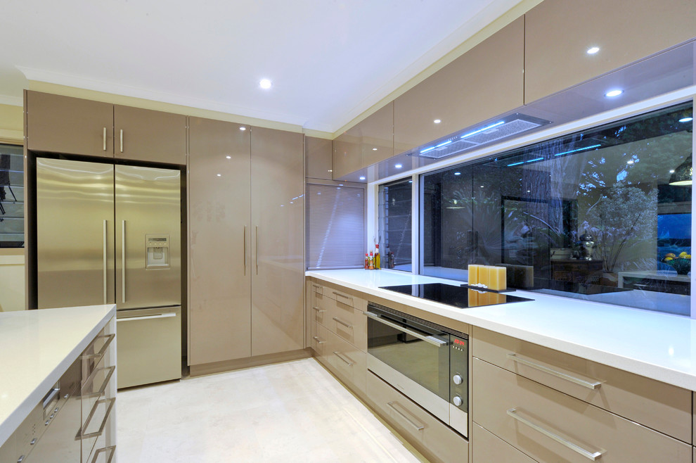 Exempel på ett litet modernt kök, med släta luckor, rostfria vitvaror, klinkergolv i porslin, en dubbel diskho, beige skåp, granitbänkskiva, fönster som stänkskydd, en halv köksö och vitt golv