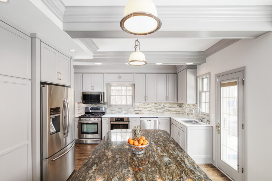Example of a large transitional l-shaped dark wood floor eat-in kitchen design in Omaha with an undermount sink, quartzite countertops, stone tile backsplash, stainless steel appliances, an island, recessed-panel cabinets, beige backsplash and gray cabinets