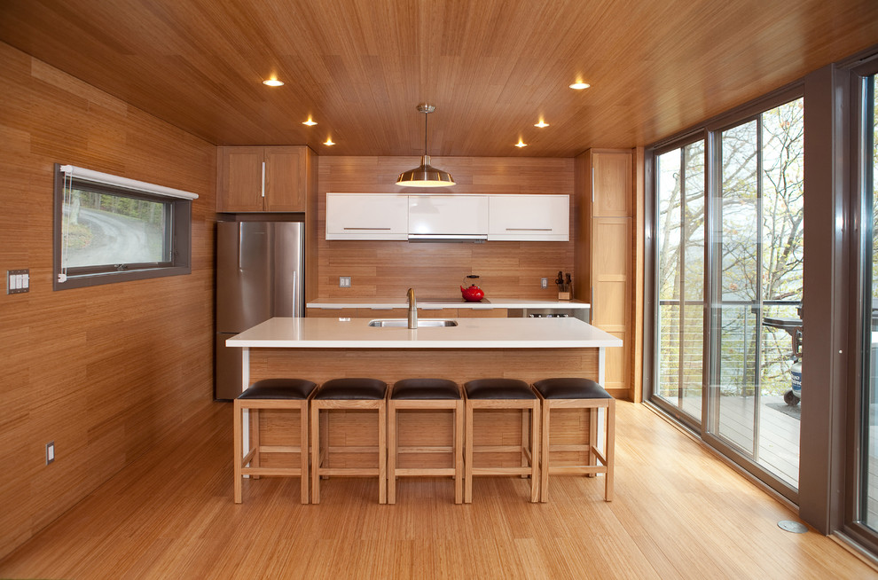 Zweizeilige Moderne Küche mit Schrankfronten im Shaker-Stil, hellbraunen Holzschränken, Küchengeräten aus Edelstahl und braunem Holzboden in Minneapolis