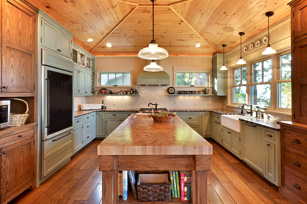 Urige Küche mit Landhausspüle, grünen Schränken und Elektrogeräten mit Frontblende in Sonstige