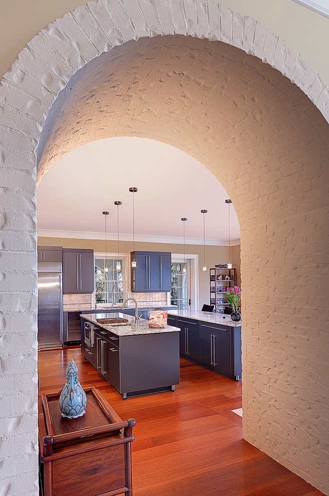 Foto de cocina contemporánea con electrodomésticos de acero inoxidable, encimera de granito y armarios con paneles lisos