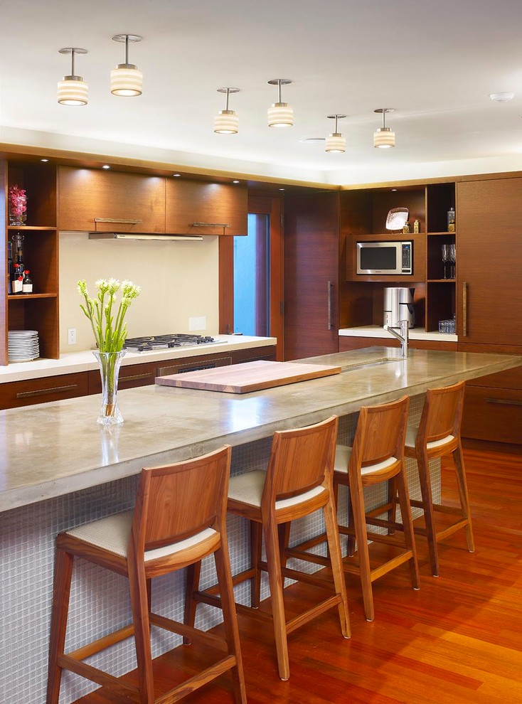 This is an example of a medium sized contemporary l-shaped kitchen/diner in Toronto with a submerged sink, flat-panel cabinets, medium wood cabinets, concrete worktops, white splashback, stone slab splashback, integrated appliances, medium hardwood flooring and an island.