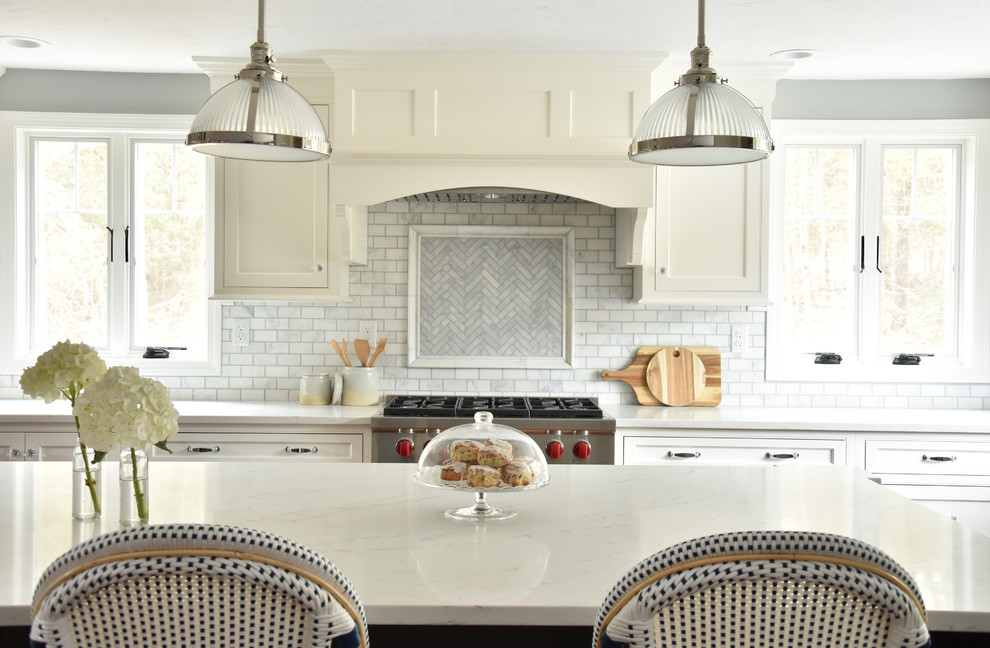 Inspiration for a classic l-shaped kitchen in Boston with a belfast sink, beaded cabinets, engineered stone countertops, marble splashback, stainless steel appliances, dark hardwood flooring and an island.