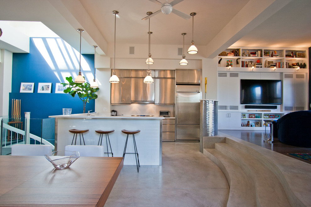 Foto på ett litet funkis kök, med släta luckor, skåp i rostfritt stål, vitt stänkskydd, rostfria vitvaror och betonggolv