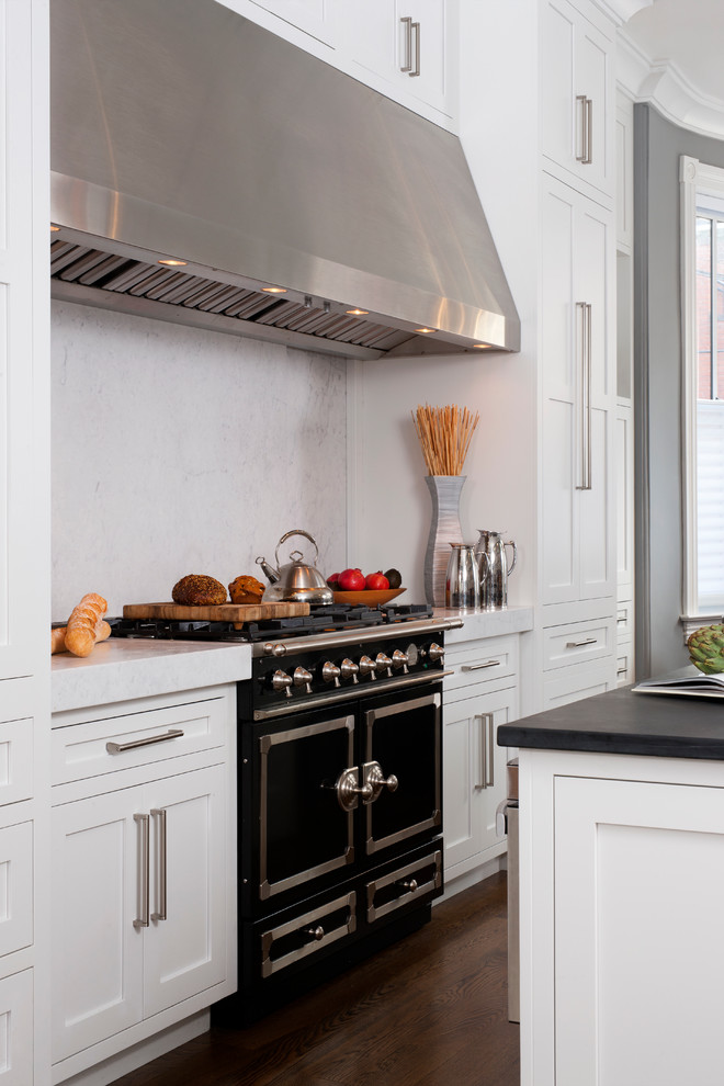 Design ideas for a large traditional galley kitchen/diner in DC Metro with shaker cabinets, white cabinets, soapstone worktops, white splashback, stone slab splashback, dark hardwood flooring, an island, a single-bowl sink and black appliances.