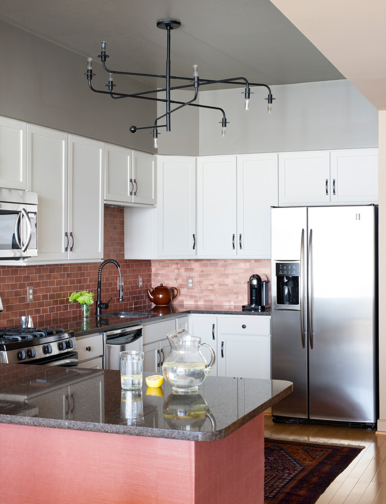 Exempel på ett mellanstort klassiskt kök, med en undermonterad diskho, luckor med infälld panel, vita skåp, bänkskiva i kvarts, rosa stänkskydd, stänkskydd i keramik, rostfria vitvaror, ljust trägolv och en halv köksö