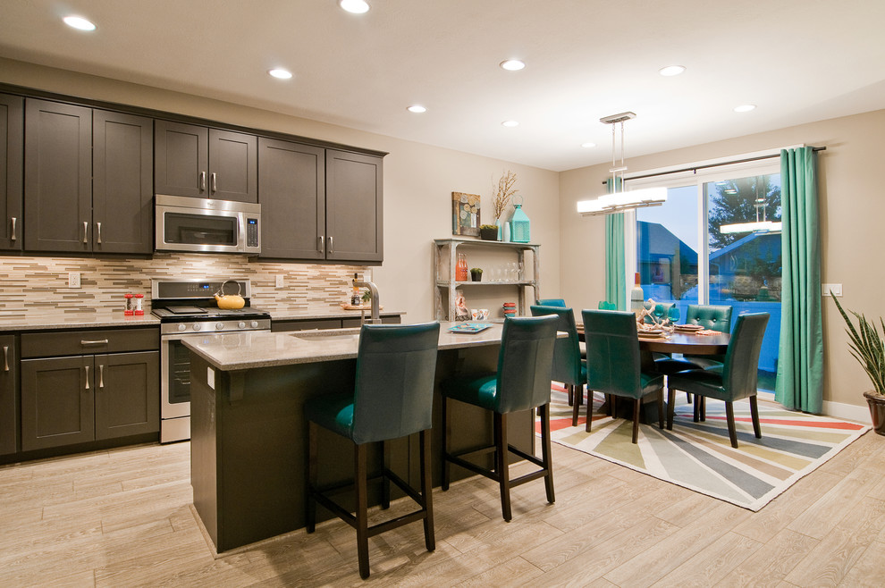 Example of a trendy l-shaped light wood floor open concept kitchen design in Salt Lake City with an undermount sink, shaker cabinets, brown cabinets, granite countertops, beige backsplash, stainless steel appliances and an island