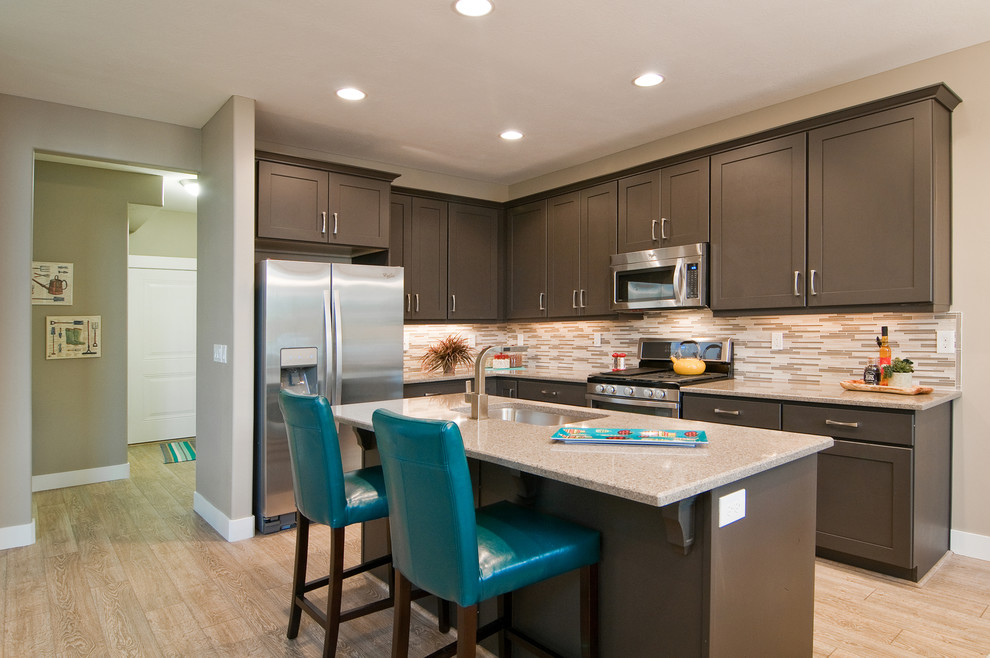 Inspiration for a contemporary l-shaped light wood floor open concept kitchen remodel in Salt Lake City with stainless steel appliances, an undermount sink, shaker cabinets, brown cabinets, granite countertops, beige backsplash and an island