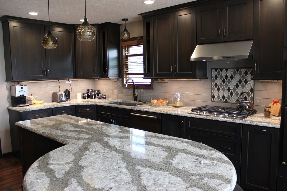 Inspiration for a mid-sized transitional l-shaped vinyl floor and multicolored floor eat-in kitchen remodel in Other with an undermount sink, flat-panel cabinets, gray cabinets, quartz countertops, gray backsplash, glass tile backsplash, black appliances and an island