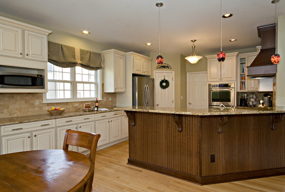 Foto på ett mellanstort vintage flerfärgad kök, med en undermonterad diskho, luckor med upphöjd panel, vita skåp, granitbänkskiva, flerfärgad stänkskydd, rostfria vitvaror, stänkskydd i stenkakel, ljust trägolv, en halv köksö och orange golv