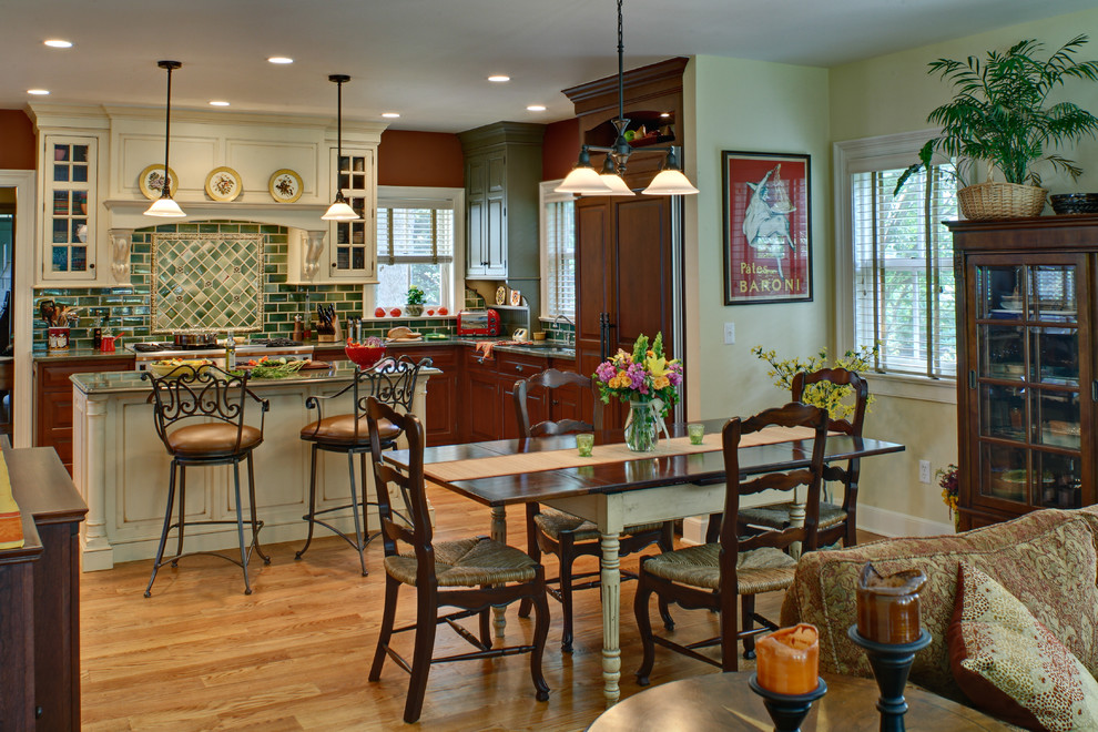 Example of a classic l-shaped open concept kitchen design in Newark with raised-panel cabinets, dark wood cabinets, green backsplash, subway tile backsplash and paneled appliances