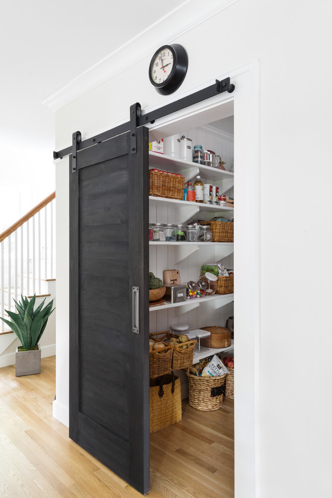 Example of a mid-sized classic light wood floor kitchen pantry design in Boston with open cabinets, white cabinets, a farmhouse sink, marble countertops, stainless steel appliances and an island