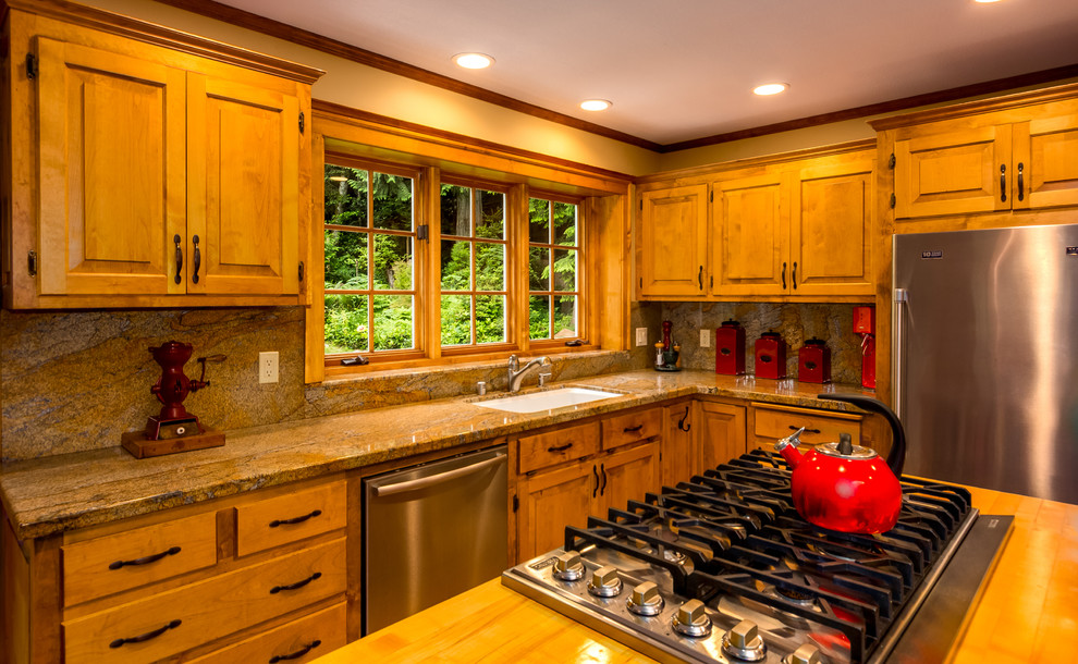 Eat-in kitchen - large farmhouse u-shaped medium tone wood floor eat-in kitchen idea in Seattle with an undermount sink, raised-panel cabinets, medium tone wood cabinets, wood countertops, stone slab backsplash, stainless steel appliances and an island