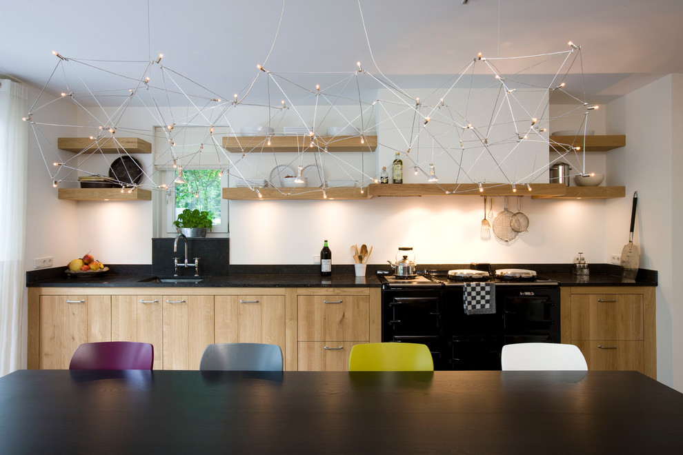 Inspiration for a contemporary kitchen remodel in New York with flat-panel cabinets, black appliances and light wood cabinets