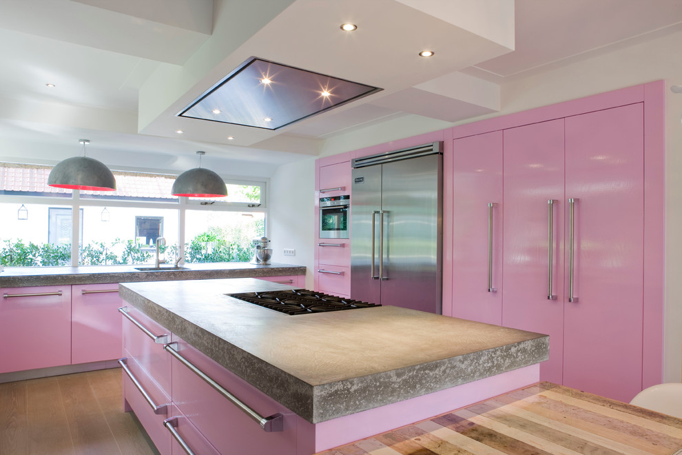 Réalisation d'une cuisine grise et rose minimaliste avec un plan de travail en béton et un électroménager en acier inoxydable.