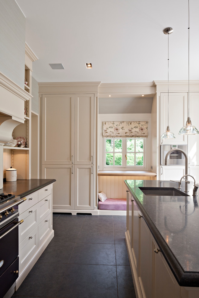 Foto de cocina contemporánea con electrodomésticos negros y armarios con paneles empotrados