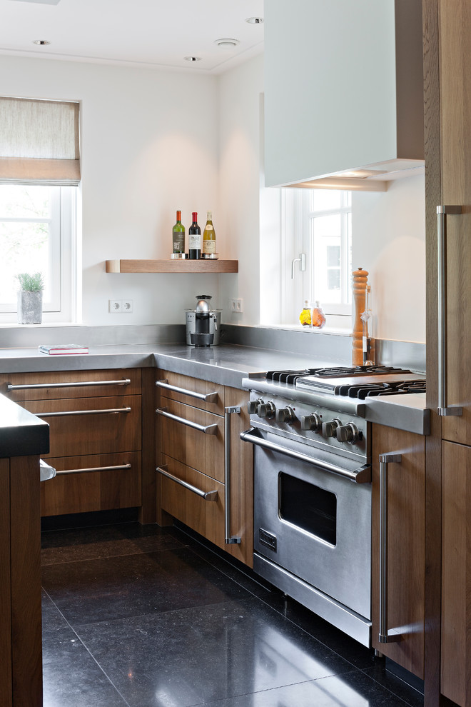Modelo de cocina contemporánea con armarios con paneles lisos, puertas de armario de madera oscura y electrodomésticos de acero inoxidable