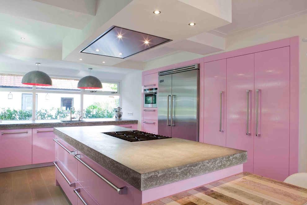 Large trendy l-shaped medium tone wood floor eat-in kitchen photo in New York with flat-panel cabinets, stainless steel appliances, an undermount sink, concrete countertops and an island
