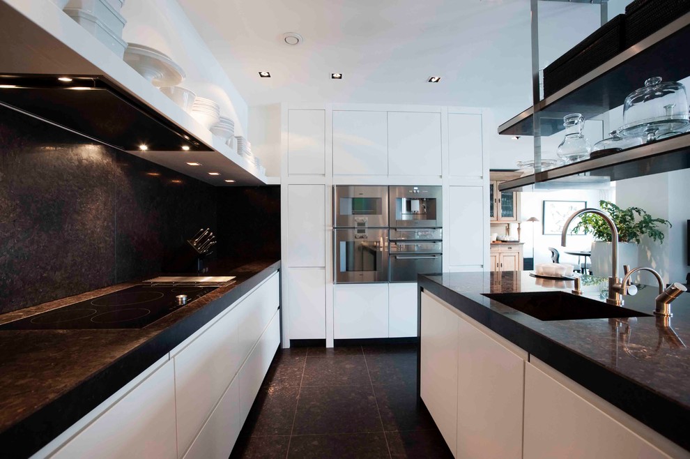 Bild på ett mellanstort funkis kök, med en undermonterad diskho, släta luckor, vita skåp, bänkskiva i koppar, svart stänkskydd, rostfria vitvaror och en halv köksö