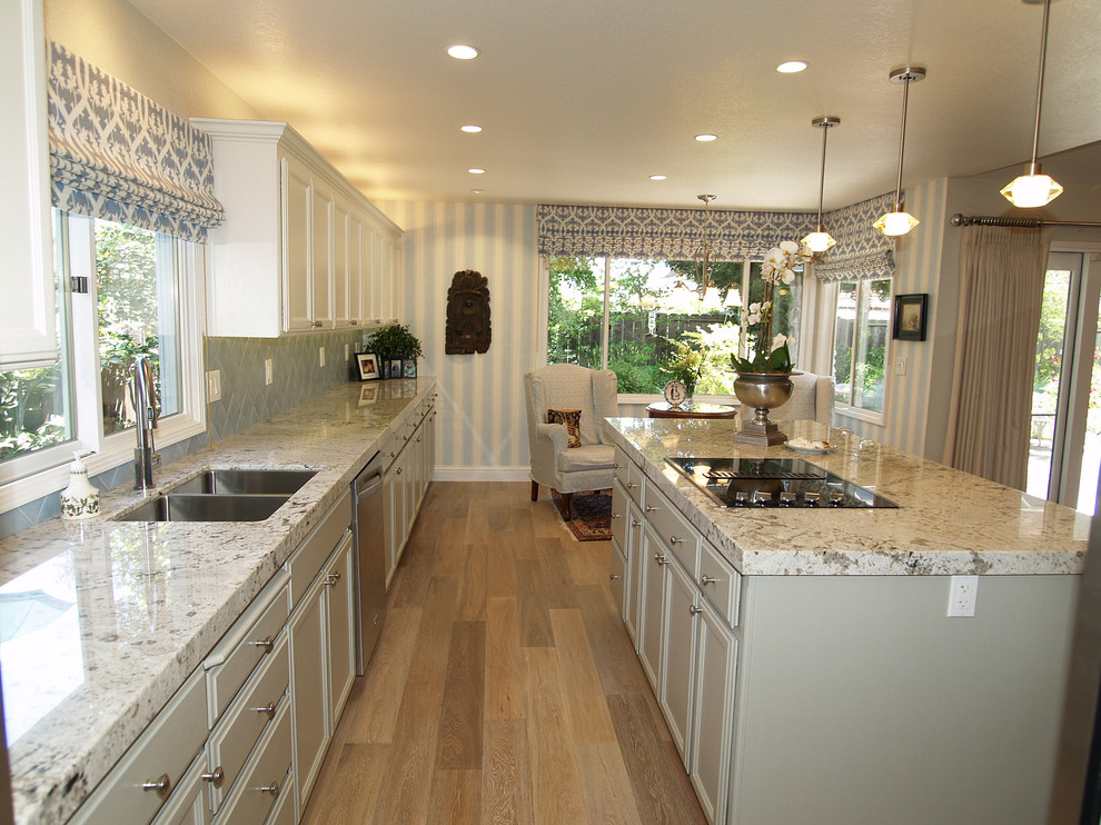 Mid-sized elegant single-wall light wood floor open concept kitchen photo in Sacramento with an undermount sink, recessed-panel cabinets, gray cabinets, granite countertops, blue backsplash, terra-cotta backsplash, stainless steel appliances and an island
