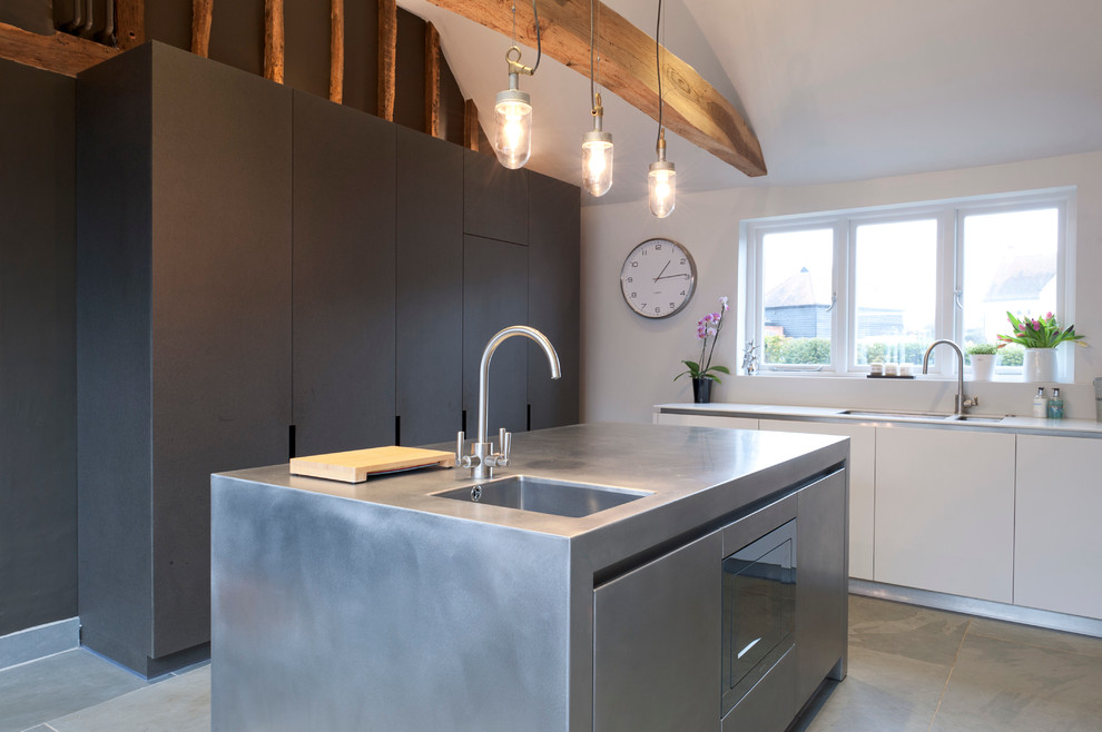 Small contemporary kitchen in Essex with a double-bowl sink, flat-panel cabinets, white cabinets, an island and concrete worktops.