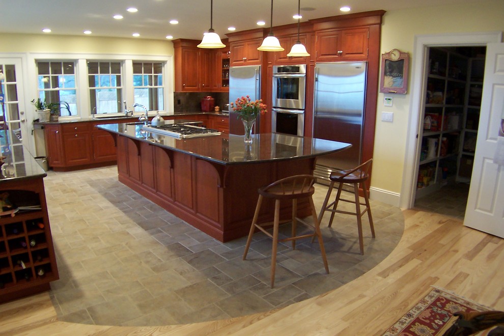 Exempel på ett stort klassiskt kök, med en undermonterad diskho, luckor med upphöjd panel, skåp i mellenmörkt trä, granitbänkskiva, grönt stänkskydd, stänkskydd i sten, rostfria vitvaror och en köksö