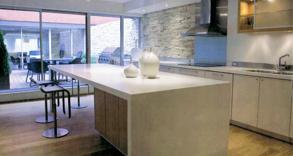 Photo of a medium sized contemporary l-shaped kitchen/diner in Toronto with a double-bowl sink, flat-panel cabinets, beige cabinets, white splashback, stainless steel appliances, light hardwood flooring and an island.