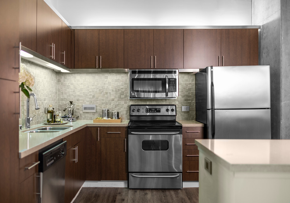 Design ideas for a medium sized industrial l-shaped enclosed kitchen in Los Angeles with a double-bowl sink, flat-panel cabinets, dark wood cabinets, engineered stone countertops, beige splashback, stone tiled splashback, stainless steel appliances, light hardwood flooring and an island.
