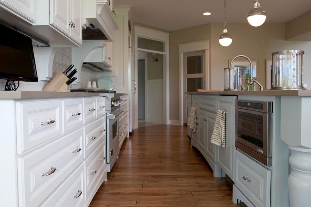 Diseño de cocina clásica renovada con armarios con paneles con relieve, electrodomésticos de acero inoxidable y puertas de armario azules