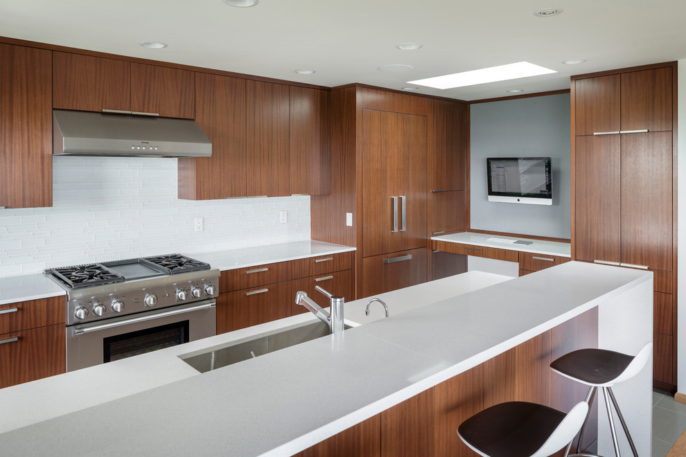 На фото: кухня в современном стиле с техникой из нержавеющей стали и телевизором с