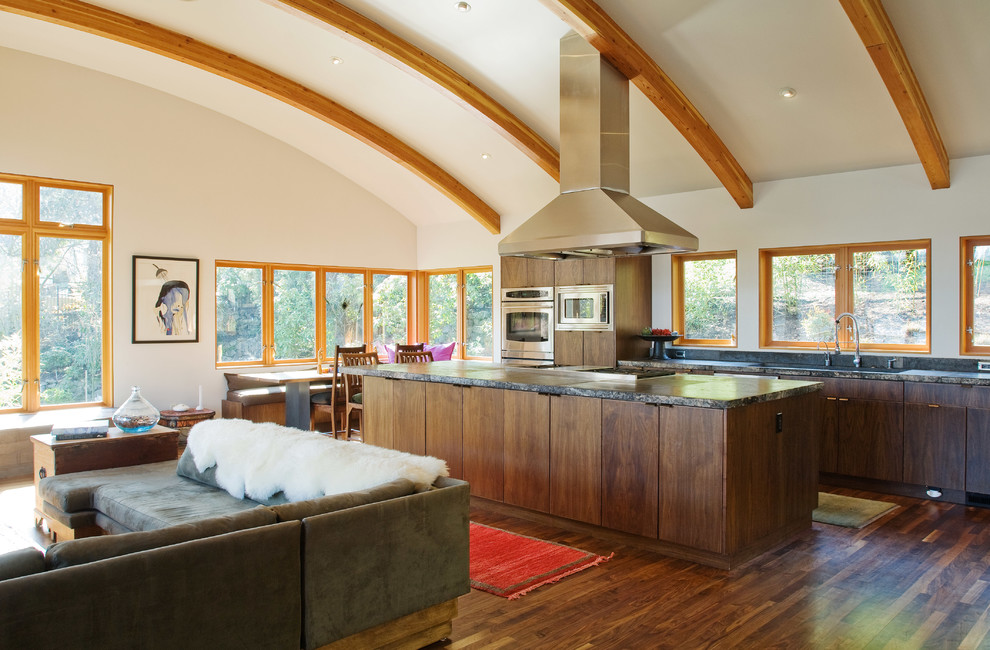 Immagine di una cucina ad ambiente unico minimal con ante lisce, ante in legno bruno e elettrodomestici in acciaio inossidabile