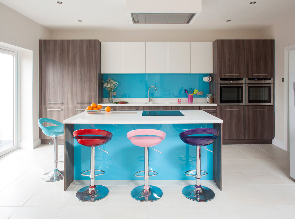 Zweizeilige Moderne Küche mit flächenbündigen Schrankfronten, dunklen Holzschränken, Küchenrückwand in Blau, Glasrückwand, Keramikboden und Kücheninsel in Sonstige