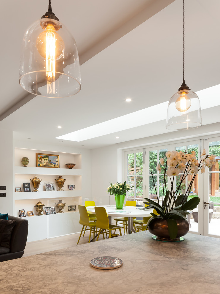 Medium sized contemporary l-shaped kitchen/diner in London with a built-in sink, flat-panel cabinets, white cabinets, marble worktops, brown splashback, wood splashback, coloured appliances, light hardwood flooring, an island and brown floors.