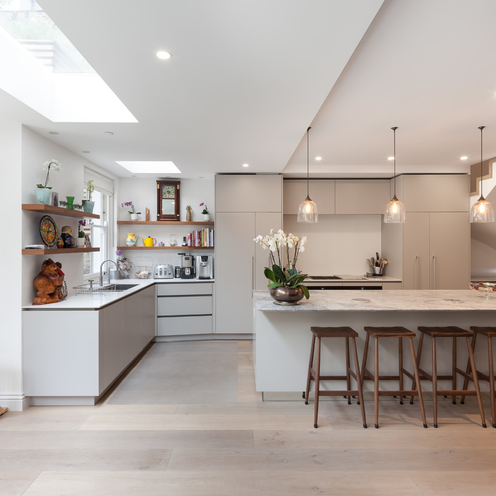 Idéer för att renovera ett mellanstort funkis kök, med en nedsänkt diskho, släta luckor, vita skåp, marmorbänkskiva, brunt stänkskydd, stänkskydd i trä, färgglada vitvaror, ljust trägolv, en köksö och brunt golv