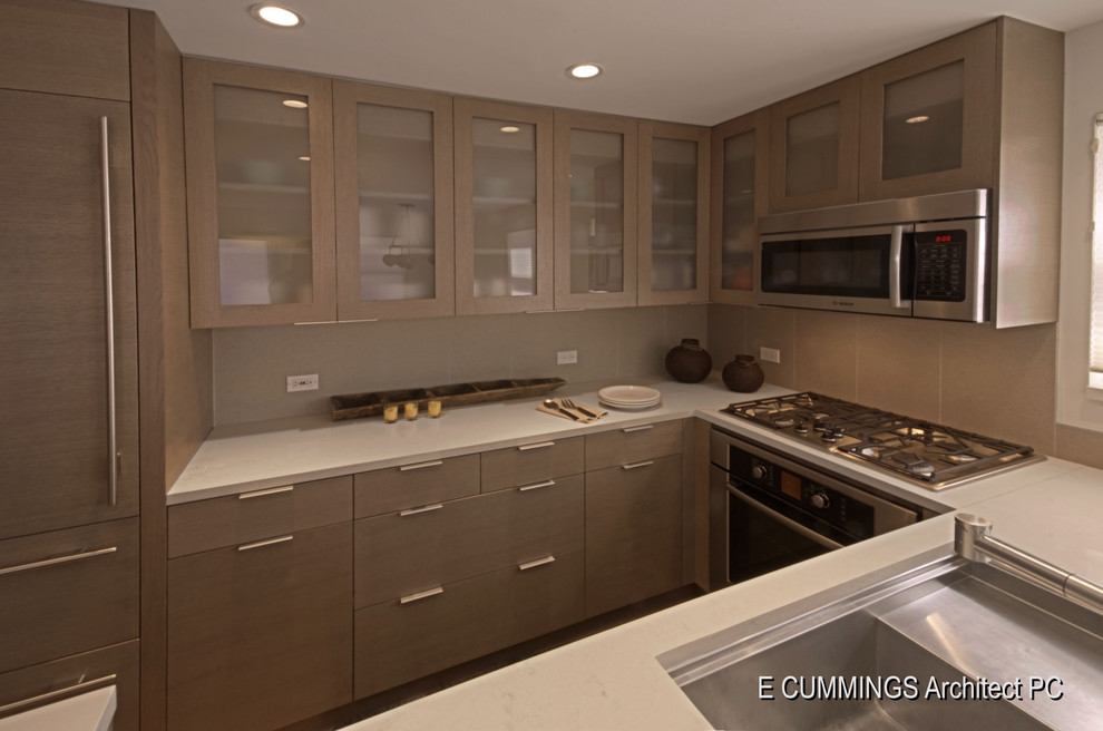 Bild på ett litet funkis kök, med en undermonterad diskho, släta luckor, grå skåp, bänkskiva i kvarts, grått stänkskydd, stänkskydd i stenkakel, rostfria vitvaror, mellanmörkt trägolv och en halv köksö