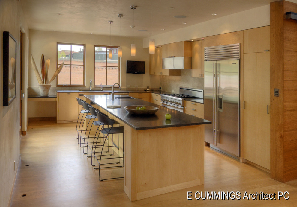 Mittelgroße Moderne Wohnküche in L-Form mit Unterbauwaschbecken, flächenbündigen Schrankfronten, hellen Holzschränken, Granit-Arbeitsplatte, Küchengeräten aus Edelstahl, braunem Holzboden und Kücheninsel in Denver