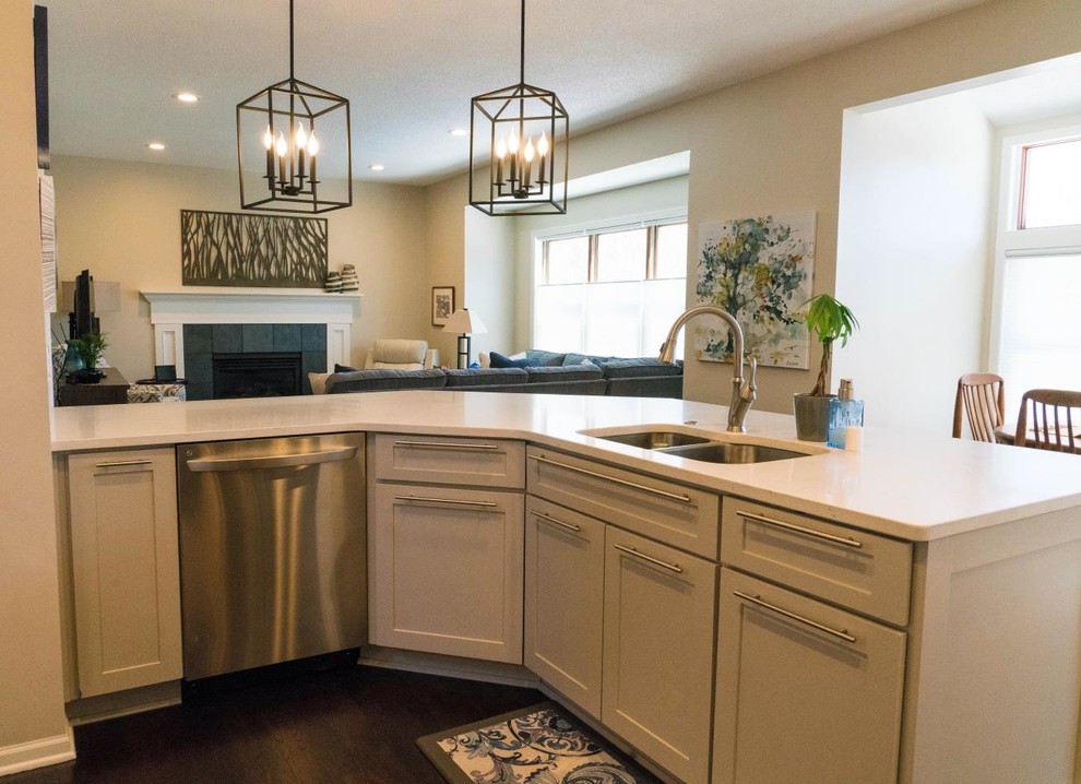 Inspiration for a mid-sized transitional dark wood floor and brown floor open concept kitchen remodel in Minneapolis with an undermount sink, shaker cabinets, white cabinets, quartzite countertops, gray backsplash, glass tile backsplash, stainless steel appliances, a peninsula and white countertops
