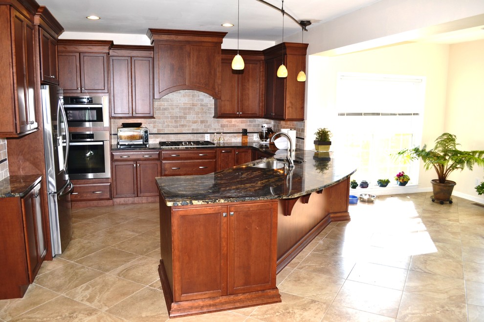 Eat-in kitchen - large transitional l-shaped ceramic tile eat-in kitchen idea in Philadelphia with an undermount sink, recessed-panel cabinets, dark wood cabinets, granite countertops, beige backsplash, porcelain backsplash, stainless steel appliances and an island