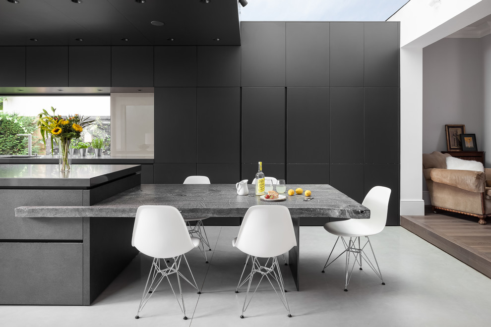 Foto di un'ampia cucina design con lavello da incasso, ante lisce, ante grigie, top in superficie solida, elettrodomestici da incasso, pavimento in cemento e pavimento grigio