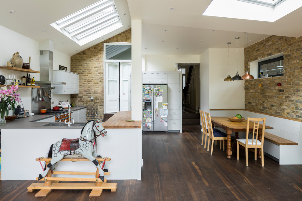 Foto di una cucina design di medie dimensioni con lavello da incasso, ante lisce, ante bianche, top in legno, parquet scuro, pavimento marrone e top marrone