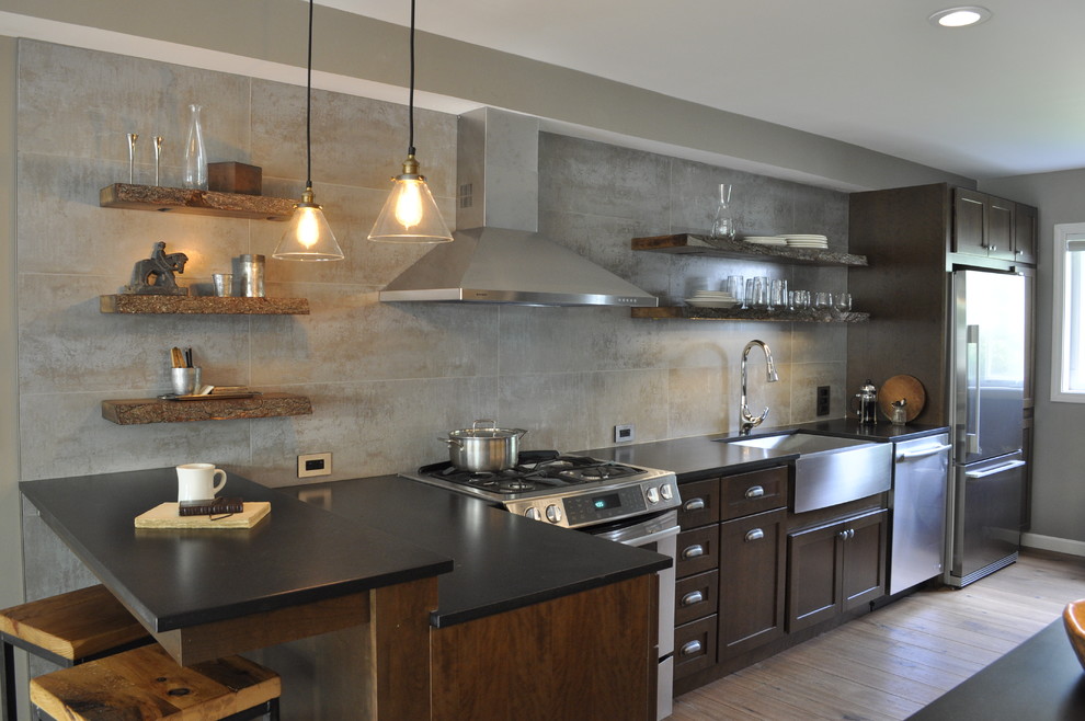 Example of a mid-sized eclectic galley dark wood floor open concept kitchen design in Burlington with a farmhouse sink, shaker cabinets, dark wood cabinets, solid surface countertops, porcelain backsplash, stainless steel appliances and a peninsula