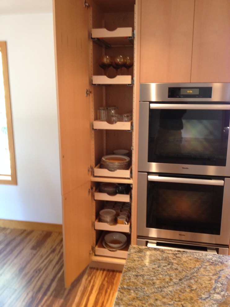 Exempel på ett mellanstort modernt kök, med en undermonterad diskho, släta luckor, skåp i mellenmörkt trä, granitbänkskiva, beige stänkskydd, stänkskydd i keramik, integrerade vitvaror, bambugolv och en köksö